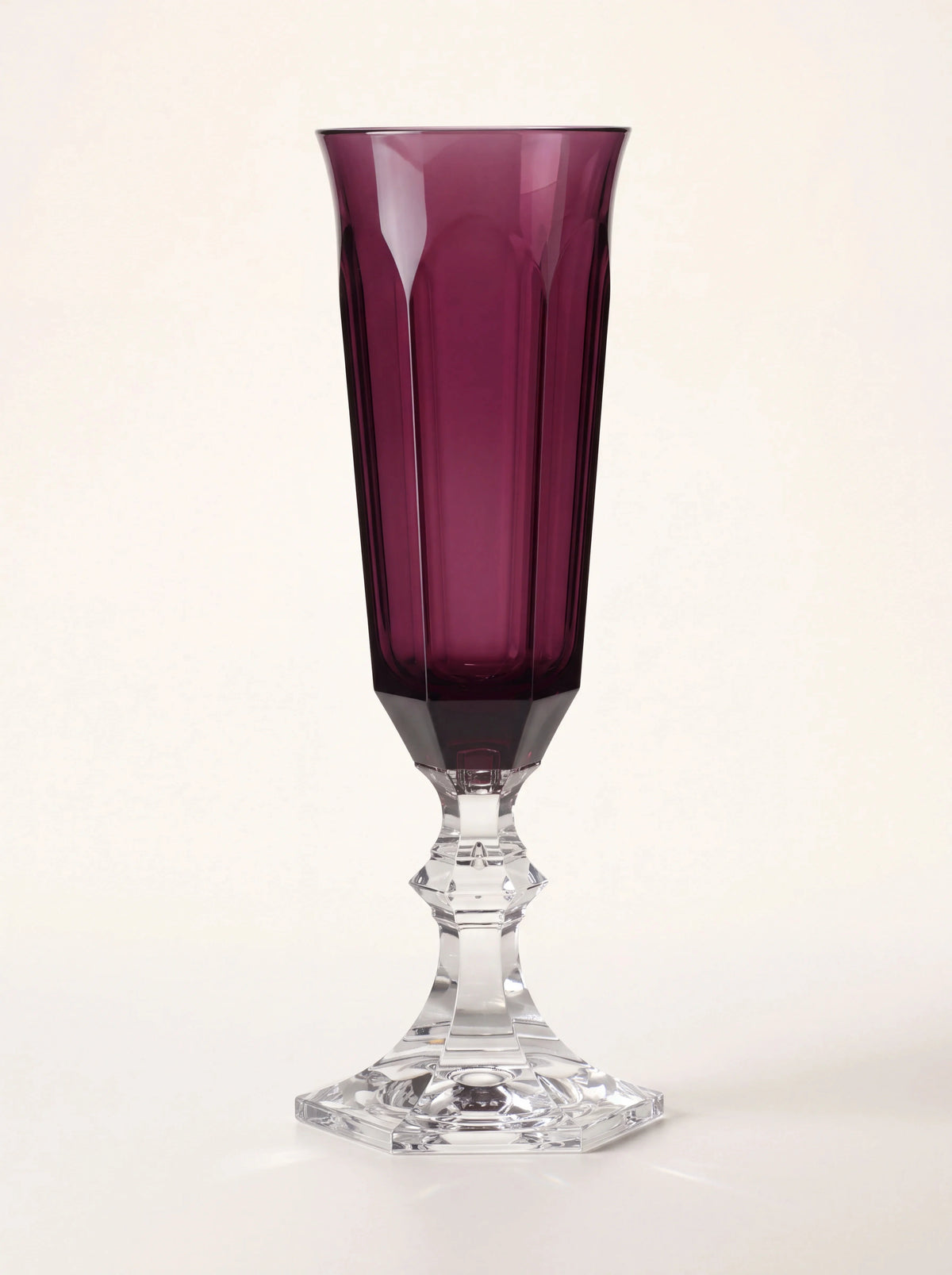 Ruby acrylic champagne flute with a faceted bowl and clear faceted stem and foot