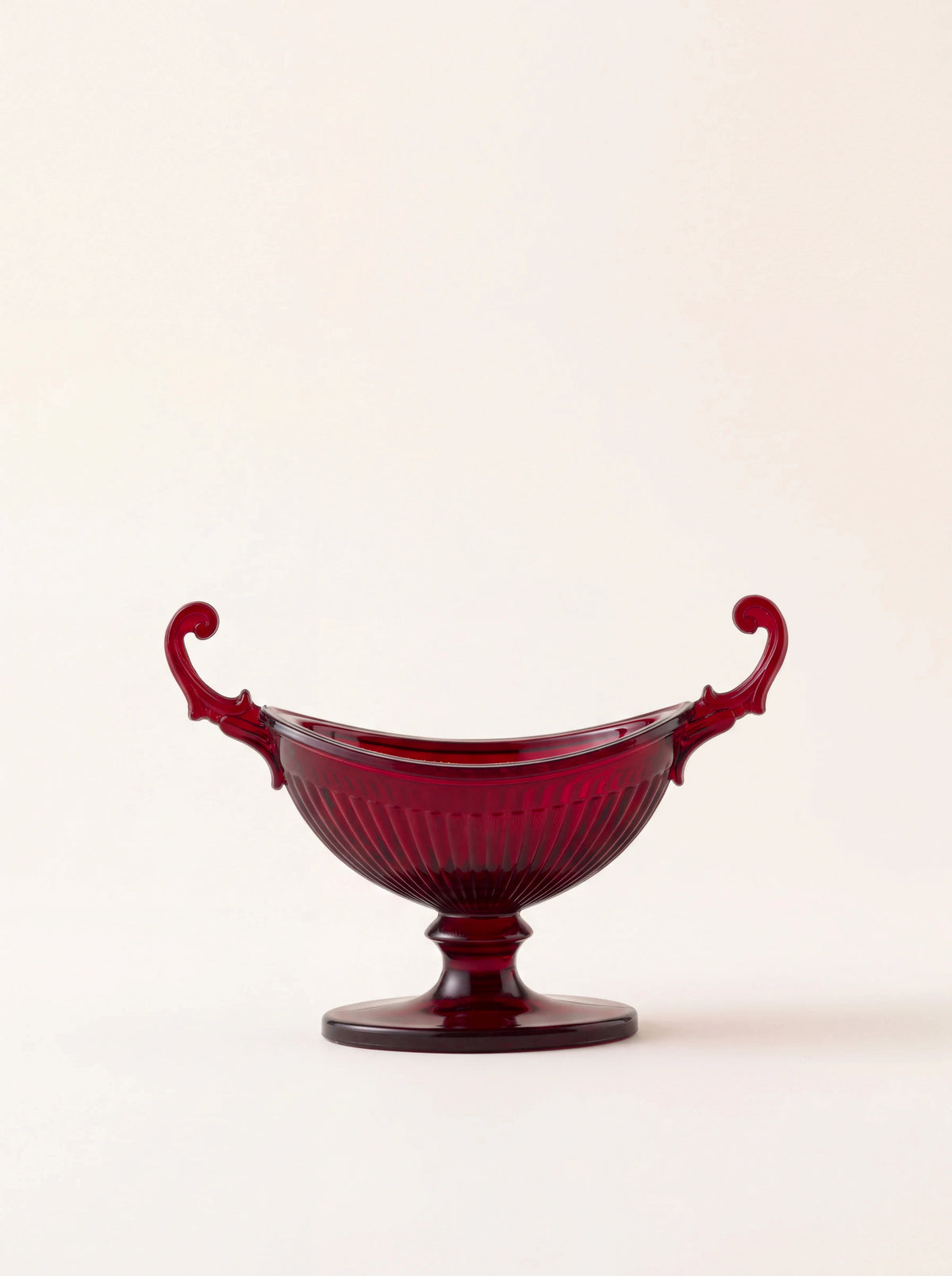 Red acrylic salt cellar with a ribbed bowl, pedestal foot, and two scrolled handles