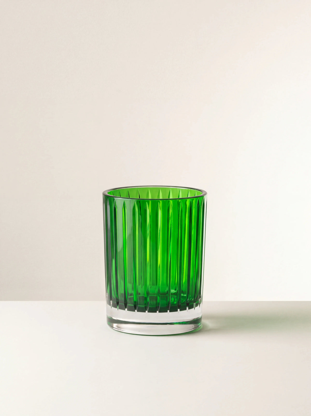 Cylindrical green acrylic tumbler with vertical fluting and a thick clear base
