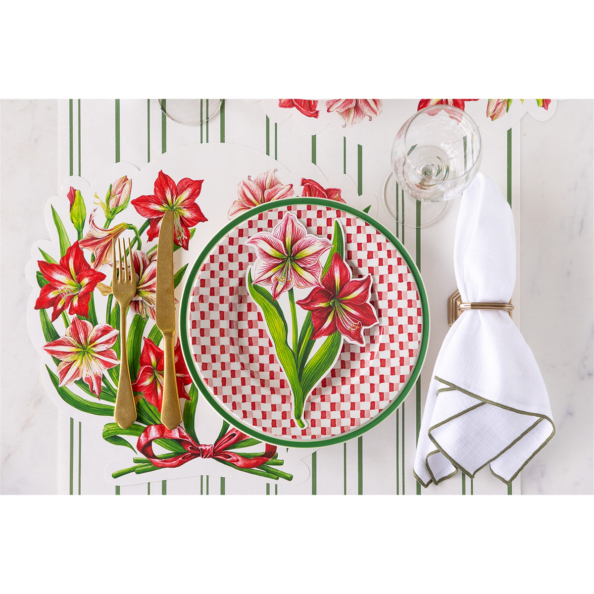 Amaryllis paper placemat laid beneath a patterned plate with cutlery and a napkin in a table setting