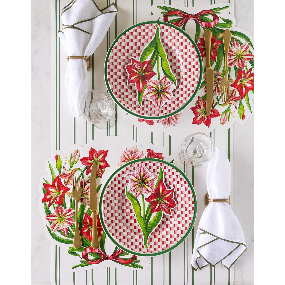 Two amaryllis paper placemats arranged across a striped table runner in a place setting for two