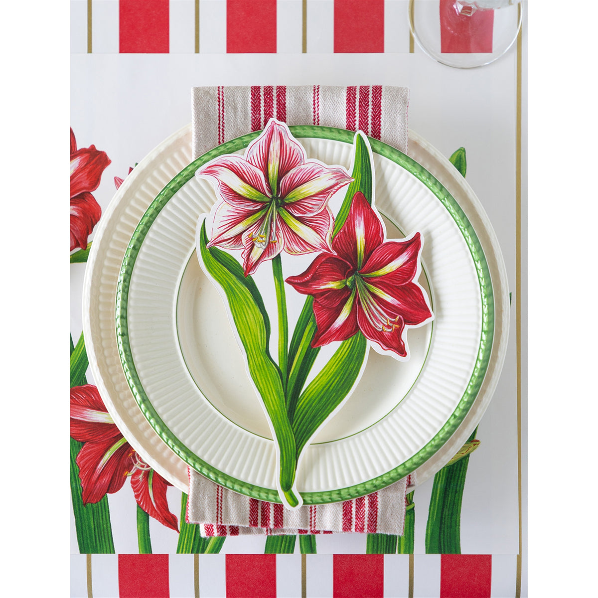 Paper amaryllis table accent arranged on a fluted plate and striped cloth napkin