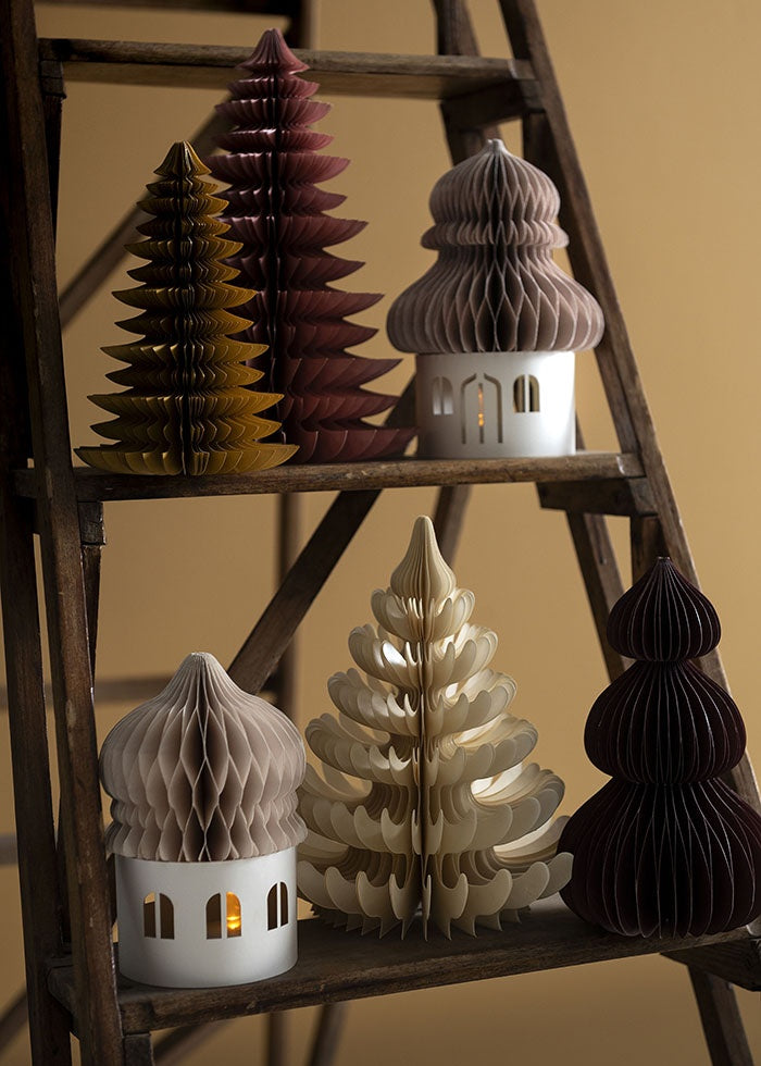Cream paper honeycomb tree displayed on a wooden stepladder shelf beside other festive decorations