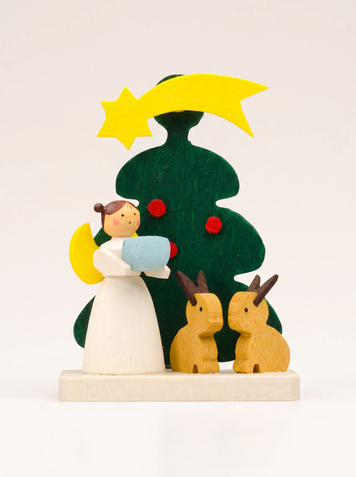 Maple wood ornament with an angel in white, two hares and a green Christmas tree topped with a shooting star