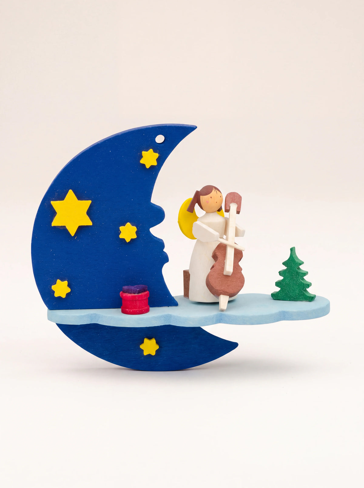 Hand-painted maple wood ornament with an angel playing cello on a cloud shelf beside a blue crescent moon