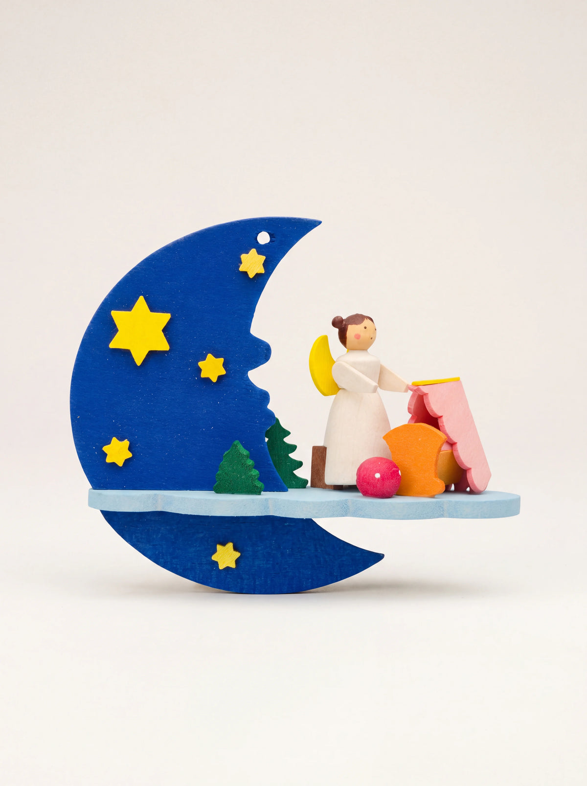 Wooden hanging ornament featuring a blue crescent moon with yellow stars and an angel standing beside a cradle