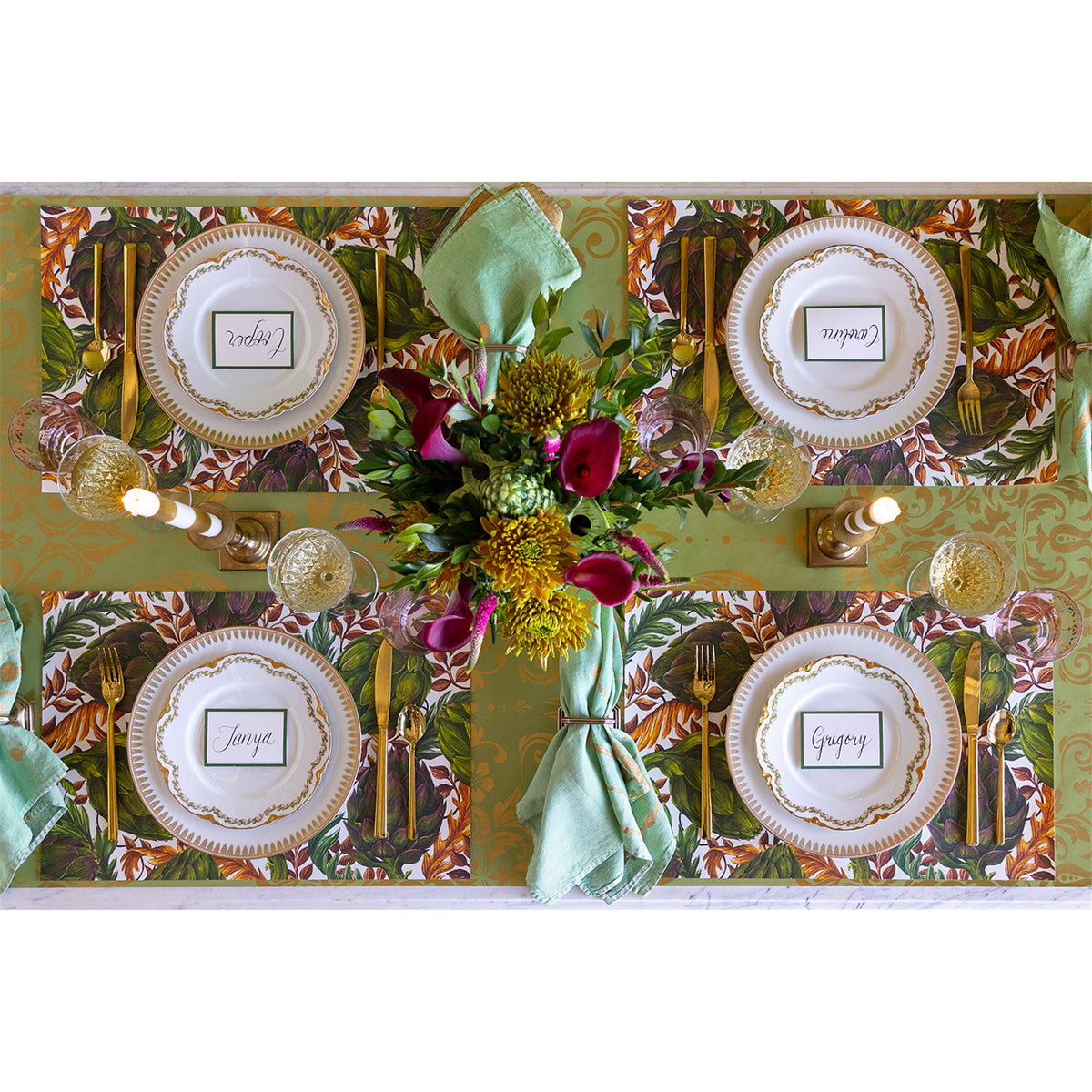 Table setting for four featuring the artichoke paper placemats, white plates and a floral centrepiece