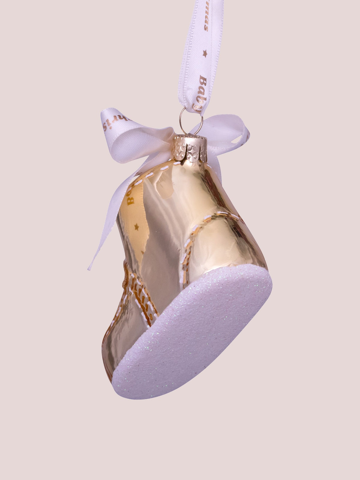 Rear and underside view of the gold glass baby shoe ornament showing the frosted glitter sole