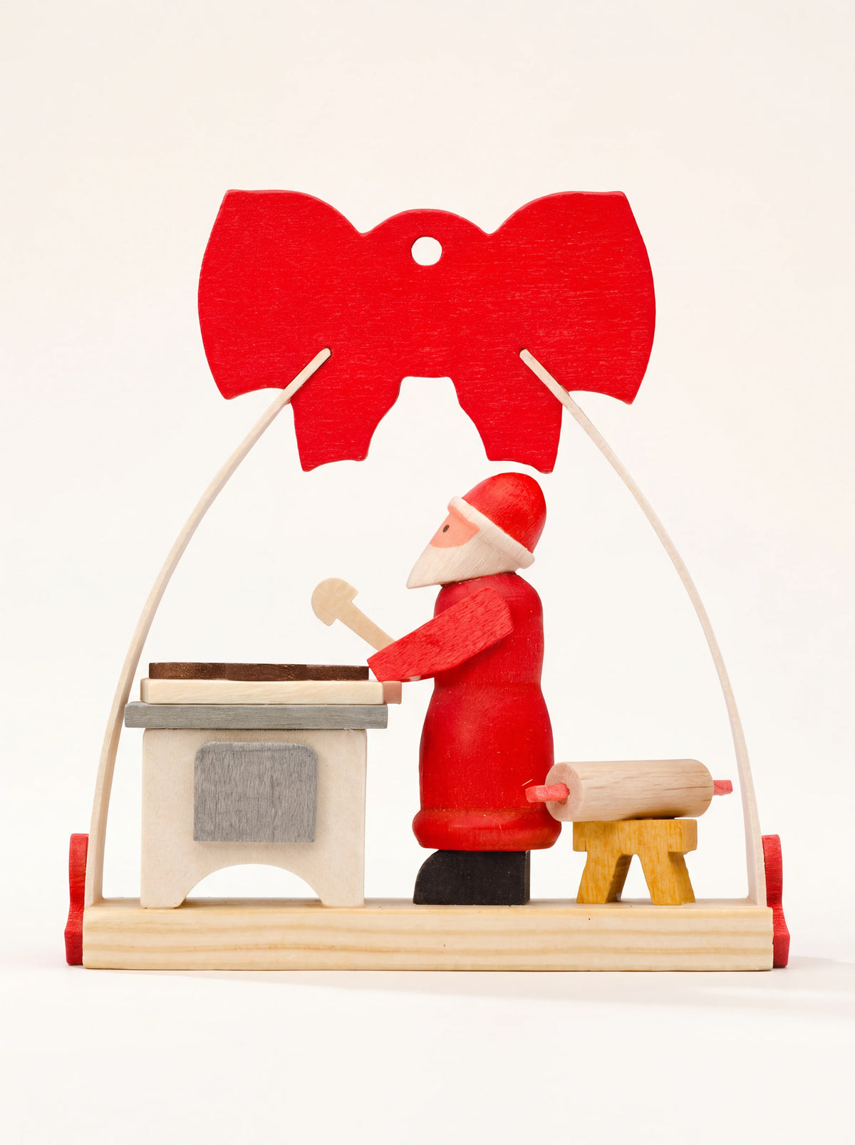 Wooden Christmas ornament with Santa Claus baking under an arched frame topped with a red bow