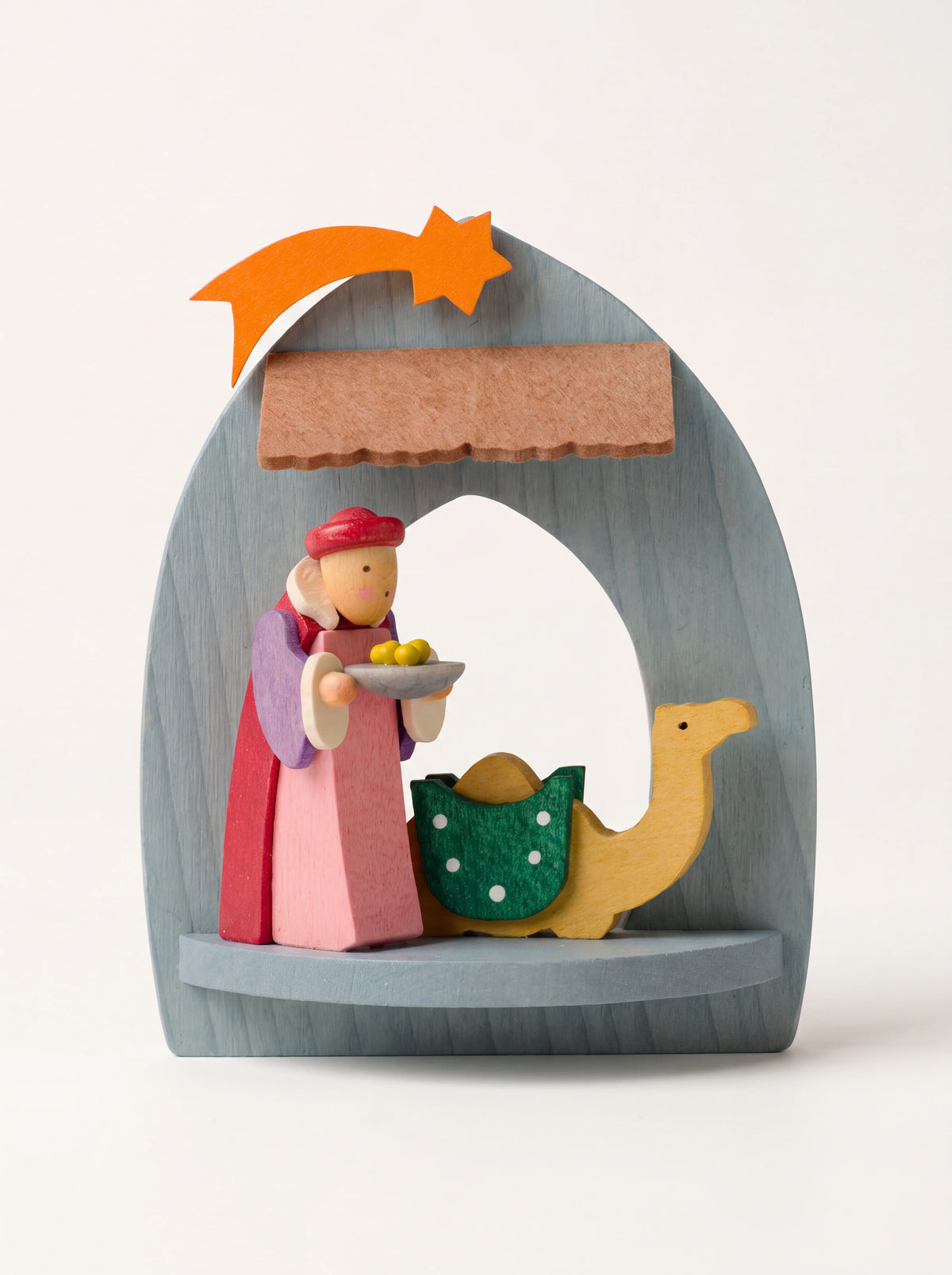 Painted maple wood nativity ornament featuring Balthasar and a camel inside an arched frame with an orange star