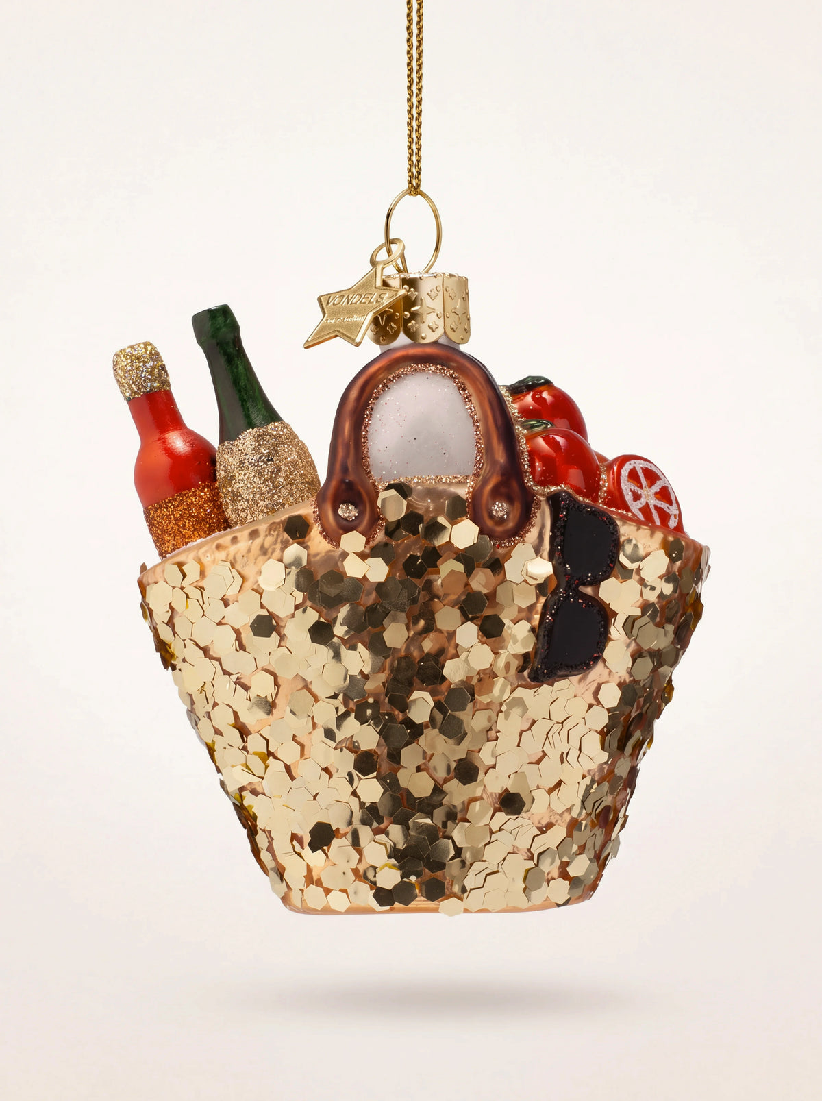 Glass beach bag Christmas ornament covered in gold sequins, with handles, bottles, and sunglasses