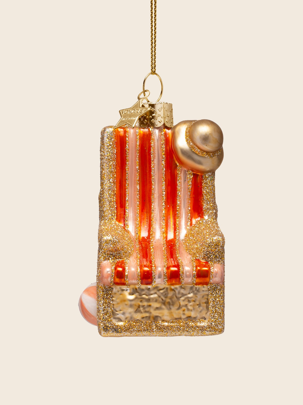 Front view of the glass beach chair ornament showing the vertical stripes and perched sun hat