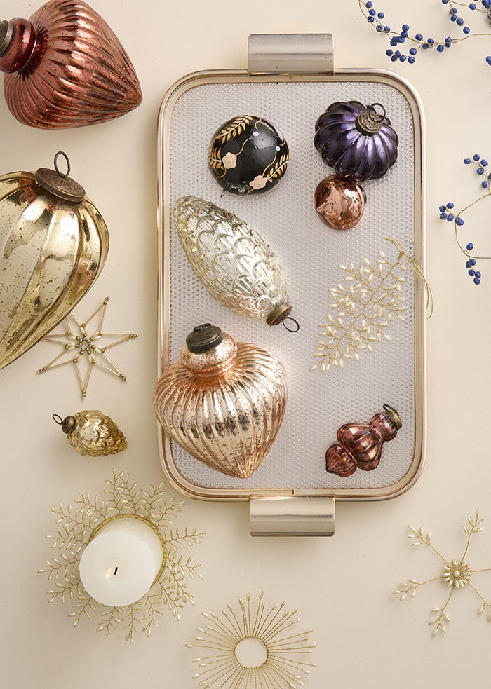 Beaded leaf ornament displayed on a tray amongst assorted glass baubles