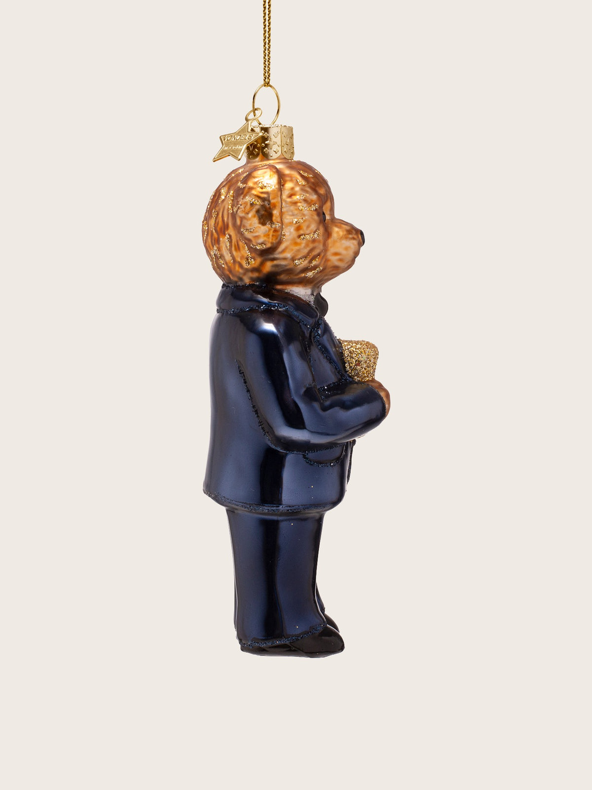 Side profile of the glass bear ornament showing its upright stance and gold star tag at the top