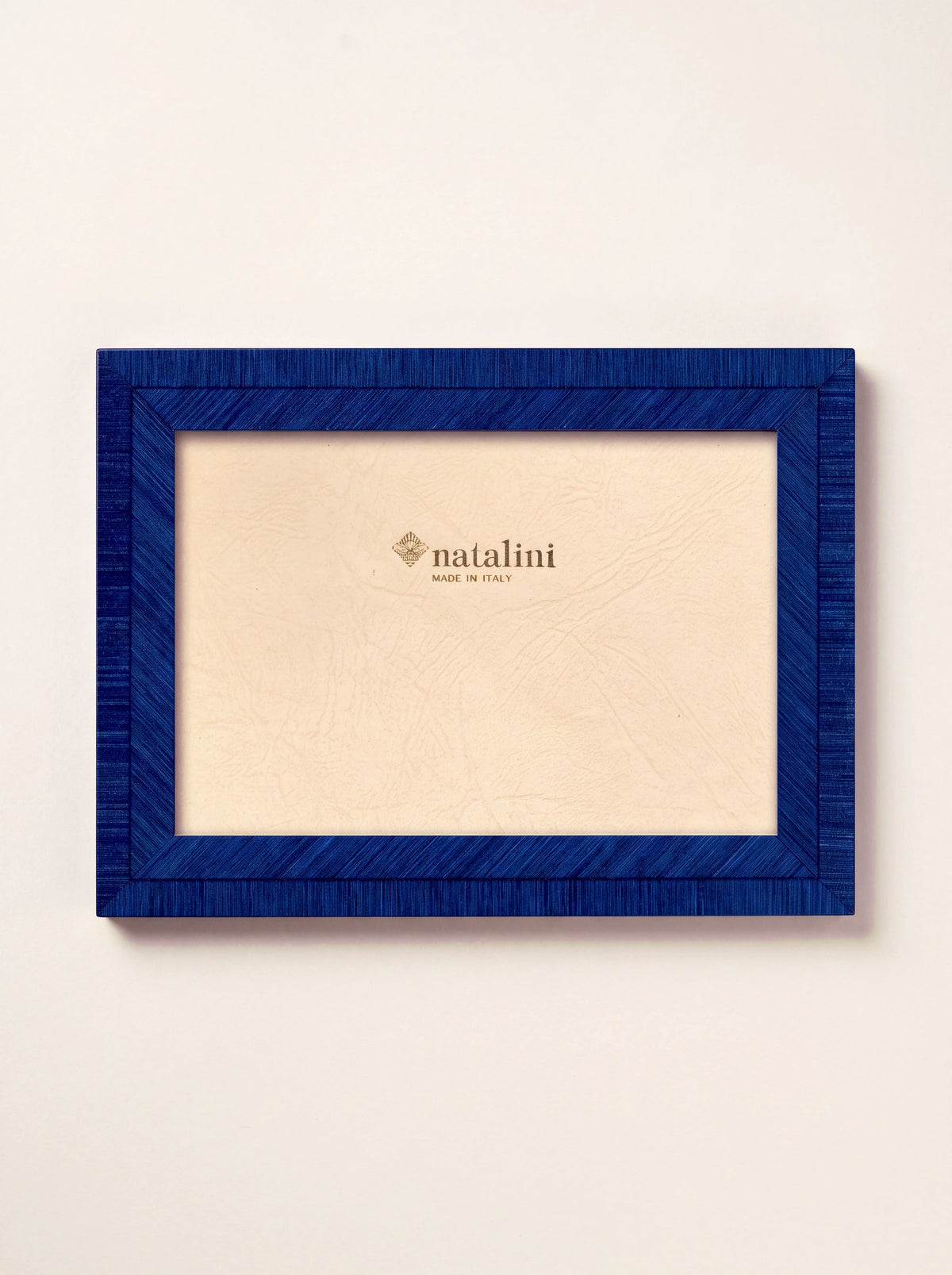Blue inlaid wood veneer photo frame in landscape orientation with insert reading natalini MADE IN ITALY