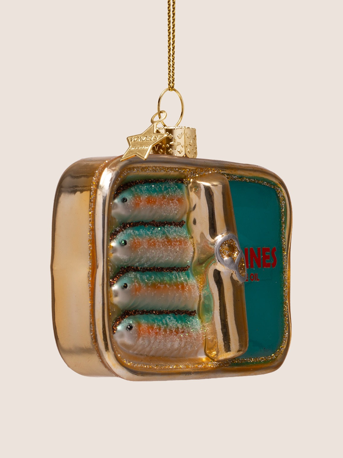 Three-quarter view of the sardine tin ornament showing the depth and raised relief of the fish