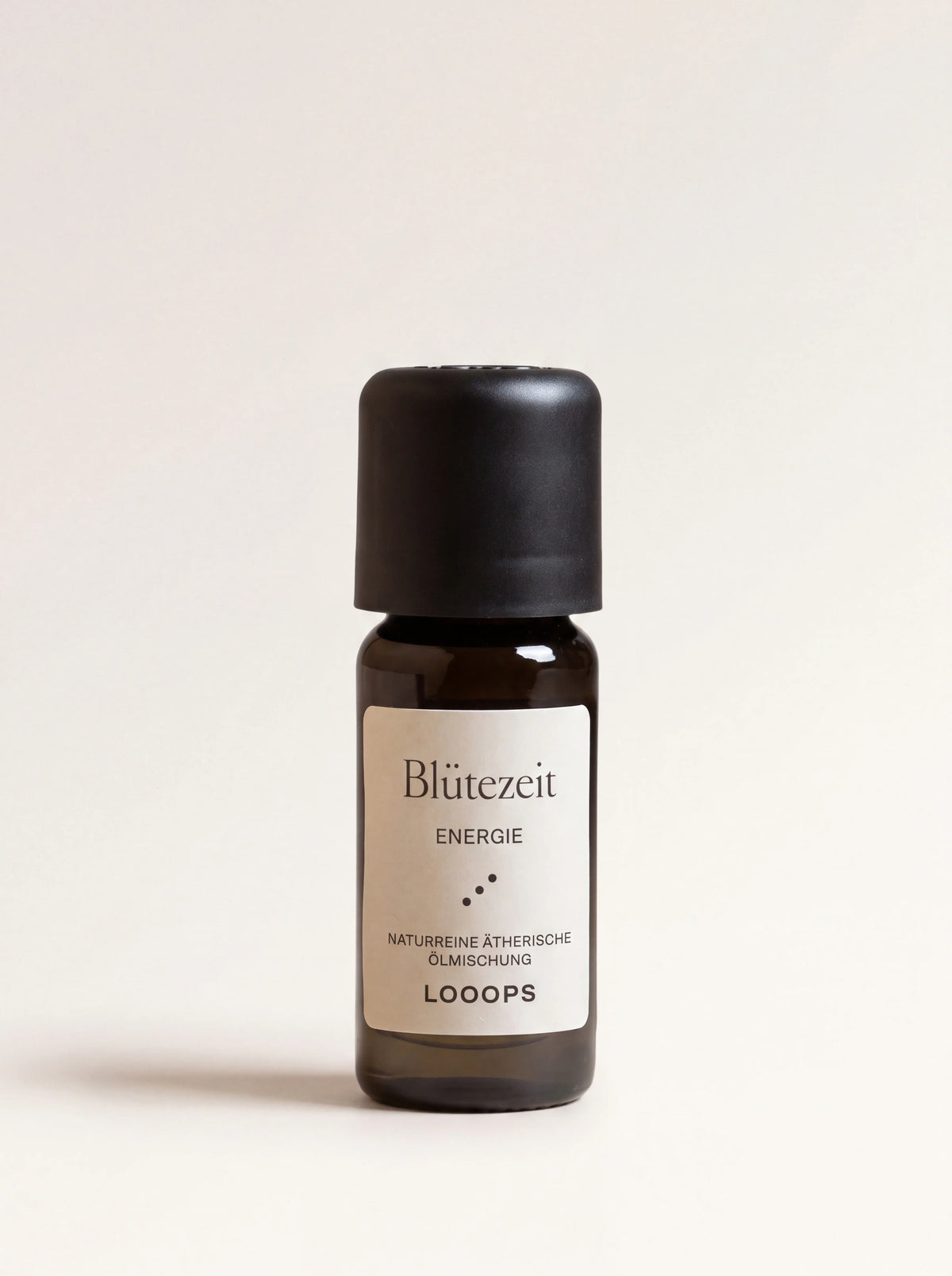 Amber glass bottle of Blütezeit essential oil with a black screw cap and label reading Blütezeit Energie