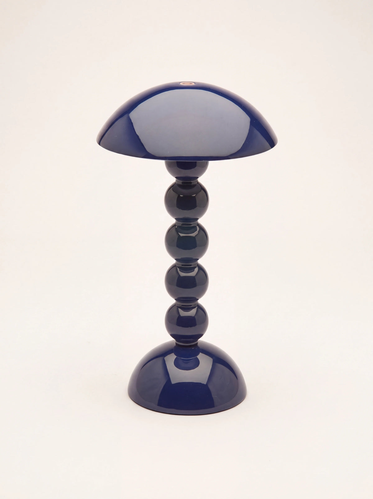 Navy bobbin table lamp in high-gloss lacquer with a domed shade and circular base
