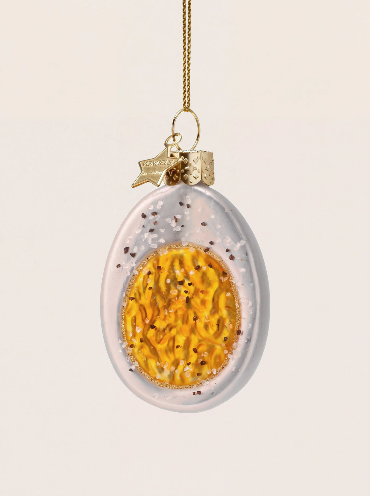 Boiled egg glass ornament shaped as a halved egg with a painted yellow yolk and glitter seasoning details
