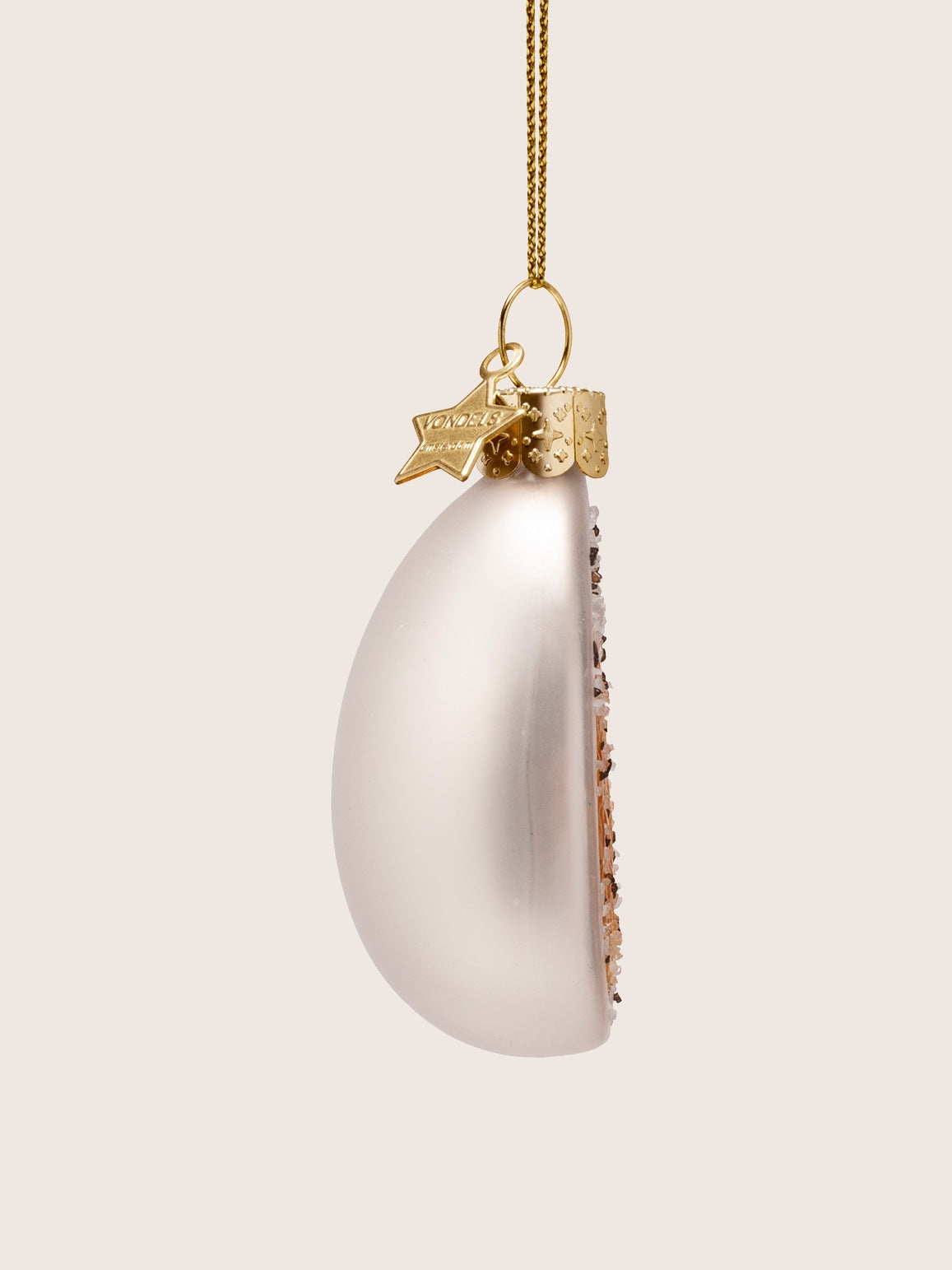 Side profile of the ornament showing the rounded white glass back and flat front face