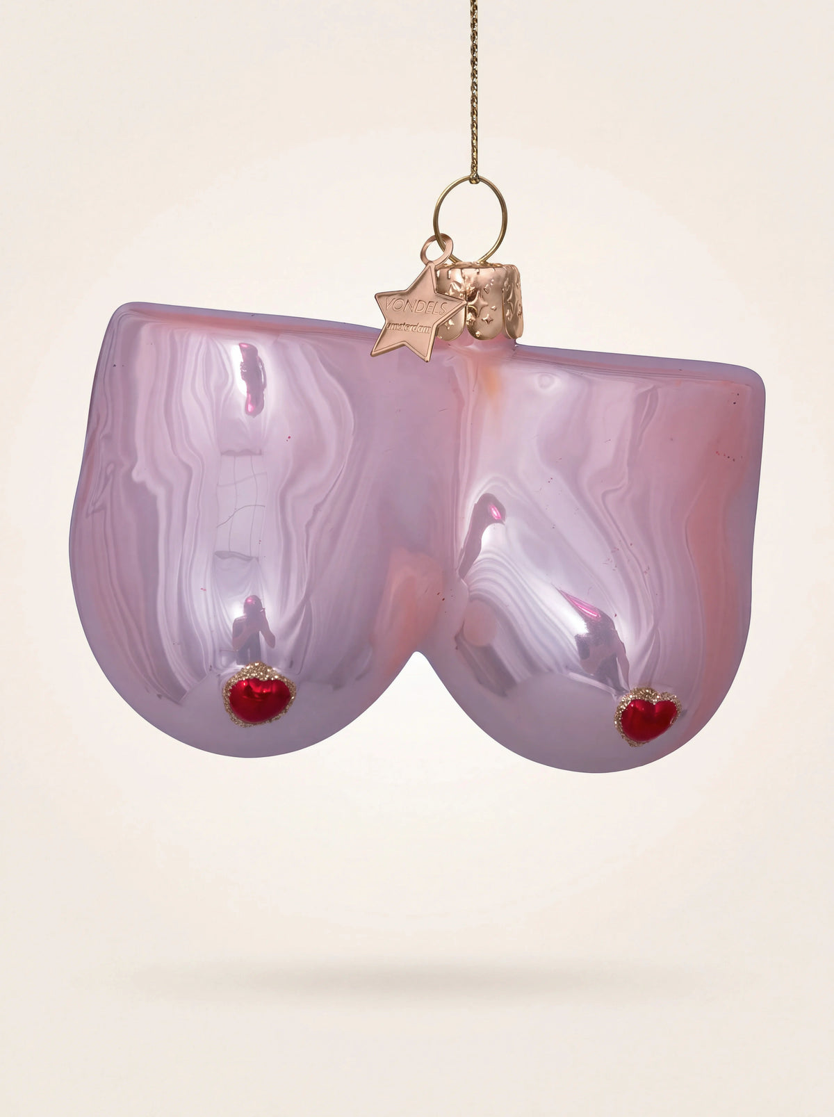 Glossy pink glass breast-shaped Christmas ornament with red heart nipples and a gold hanging loop