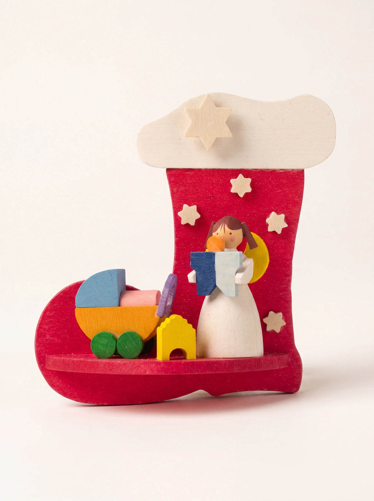 Red wooden boot ornament featuring an angel figurine, colourful toy pram and applied wooden stars