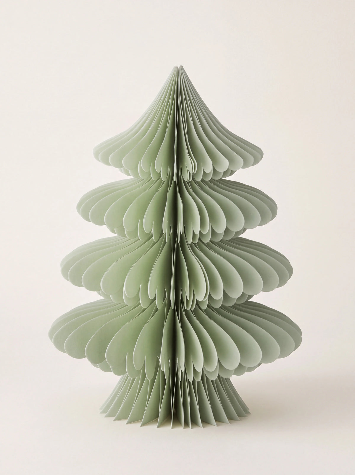 Tiered paper honeycomb tree in pale sage green with scalloped layers and a flared base
