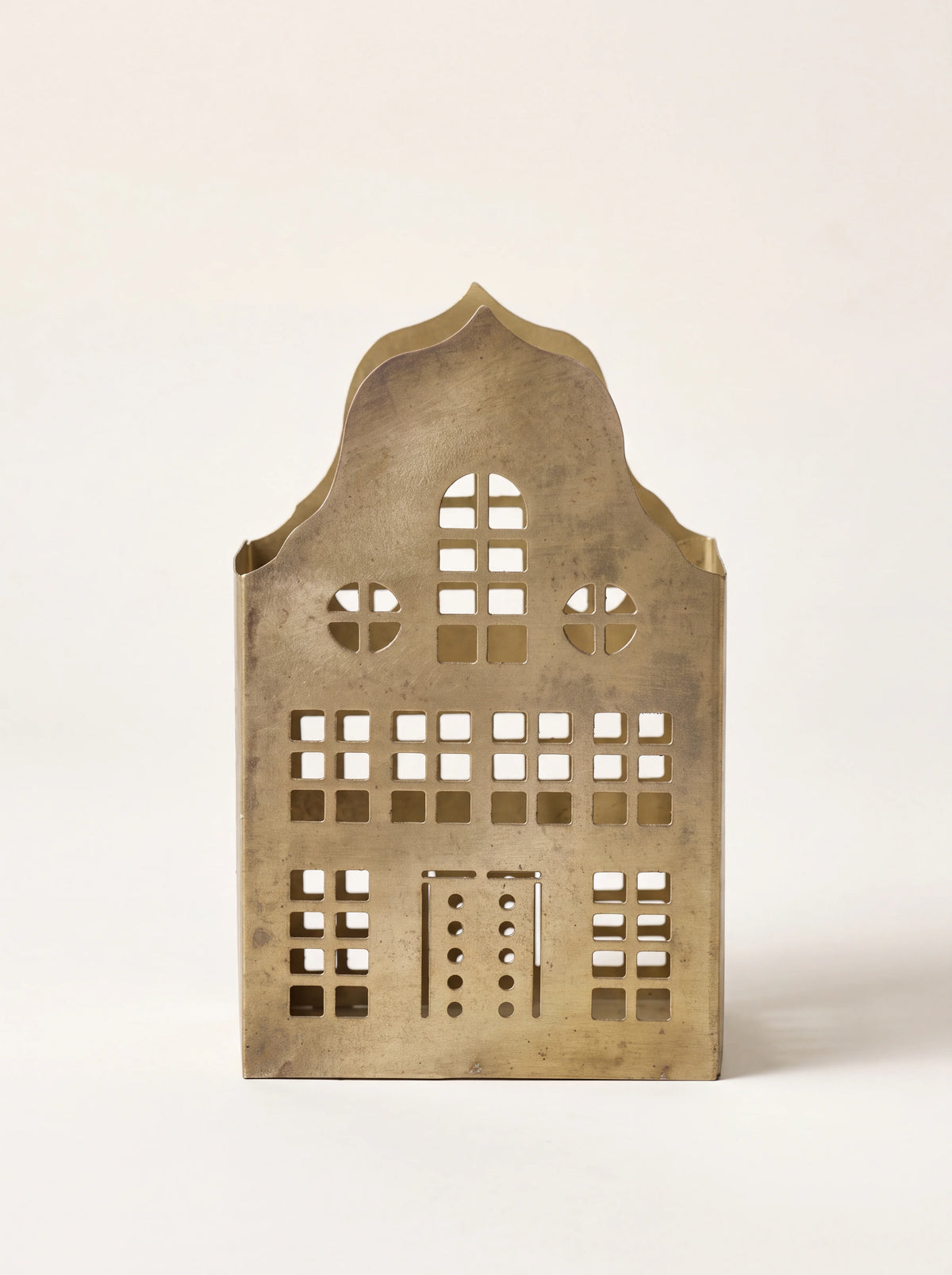 House-shaped iron candle holder in a gold finish with cutout windows and a decorative gable