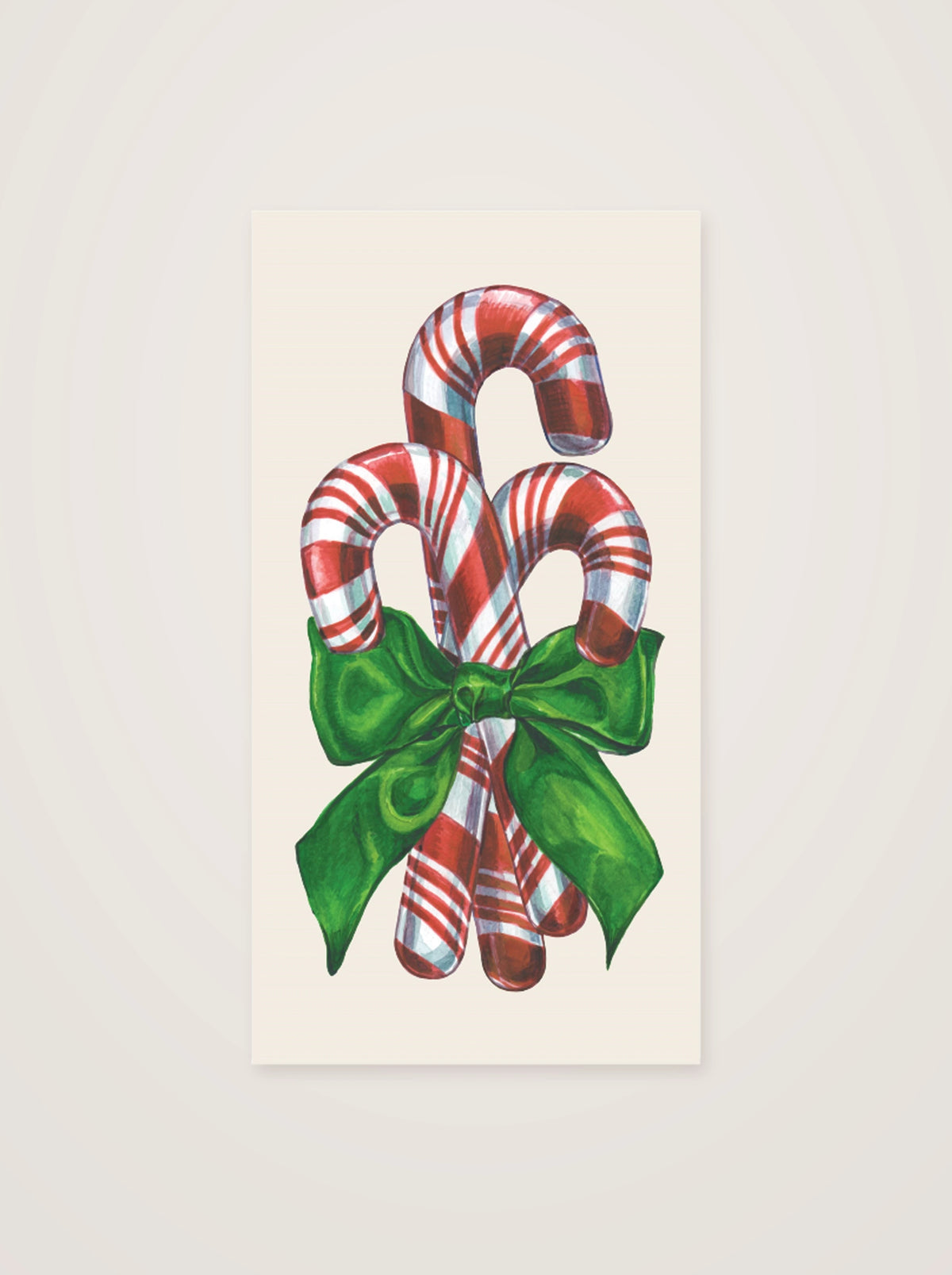 Paper guest napkin printed with a trio of candy canes and a green ribbon on a cream base