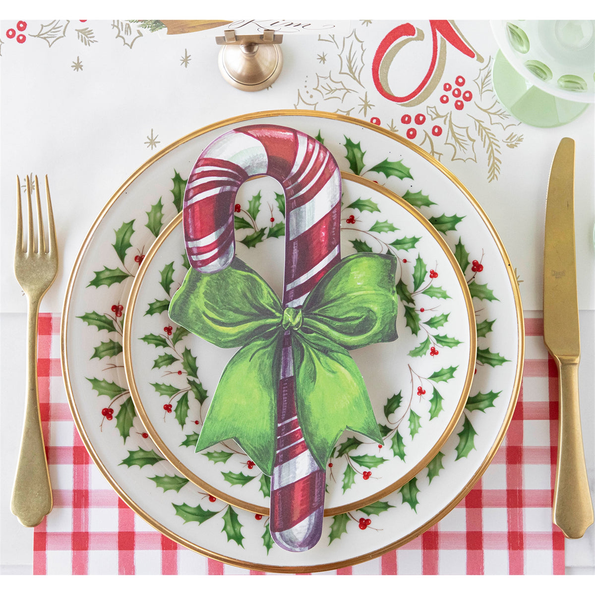Paper candy cane accent placed on a festive dinner plate as a table setting decoration