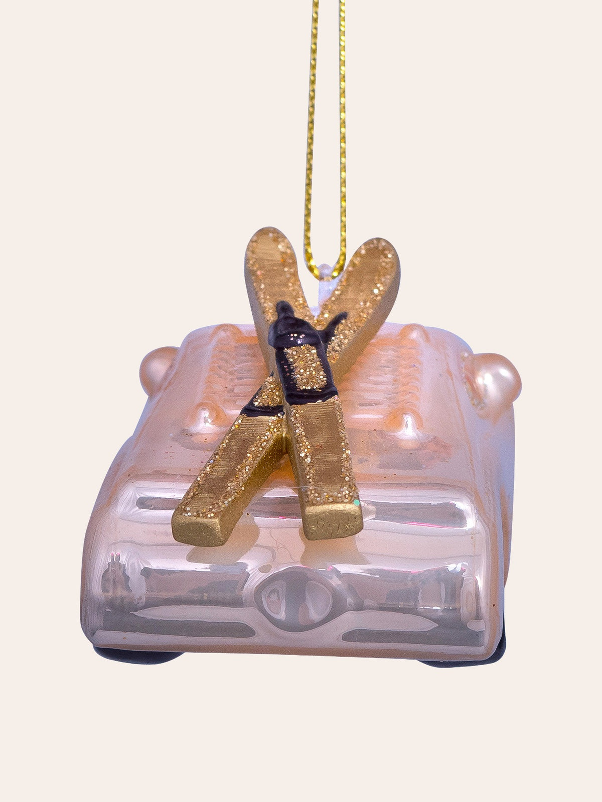 Rear view focusing on the crossed gold glitter skis with black bindings fixed atop the roof