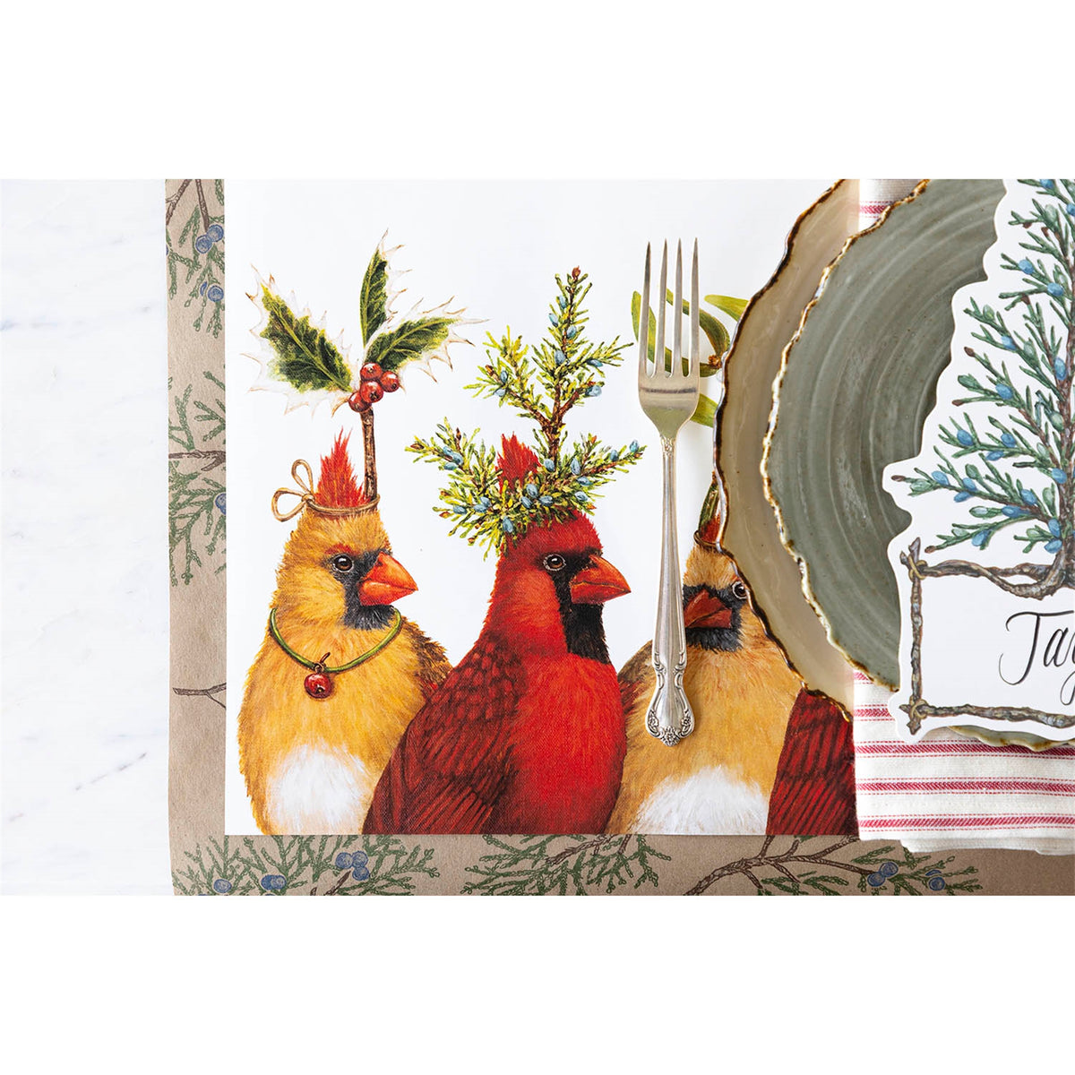 Close-up of the illustrated cardinals on a laid table set with a silver fork, napkin and ceramic plate