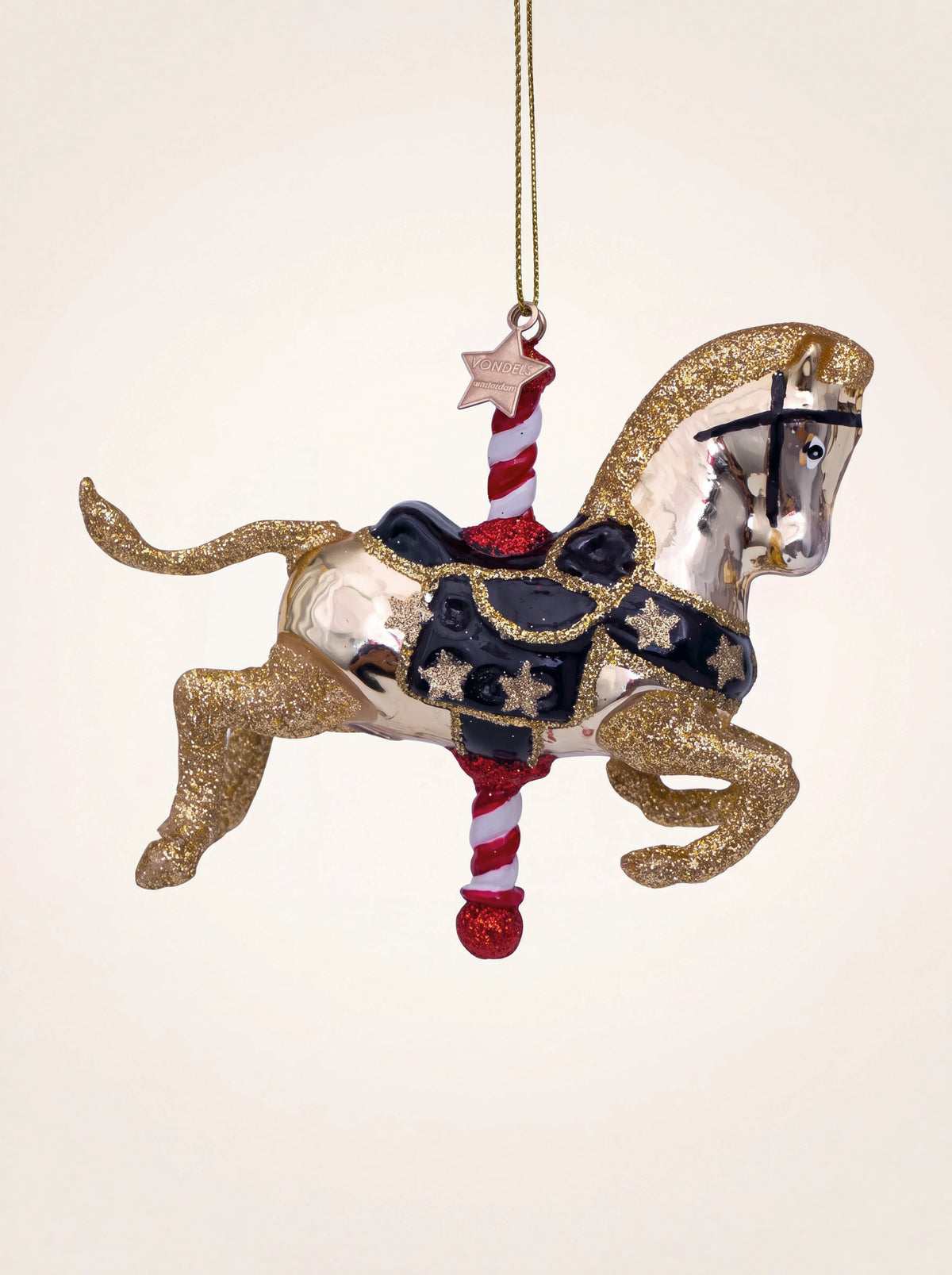 Shiny gold glass carousel horse ornament with glitter accents, black saddle, and a red-and-white striped pole