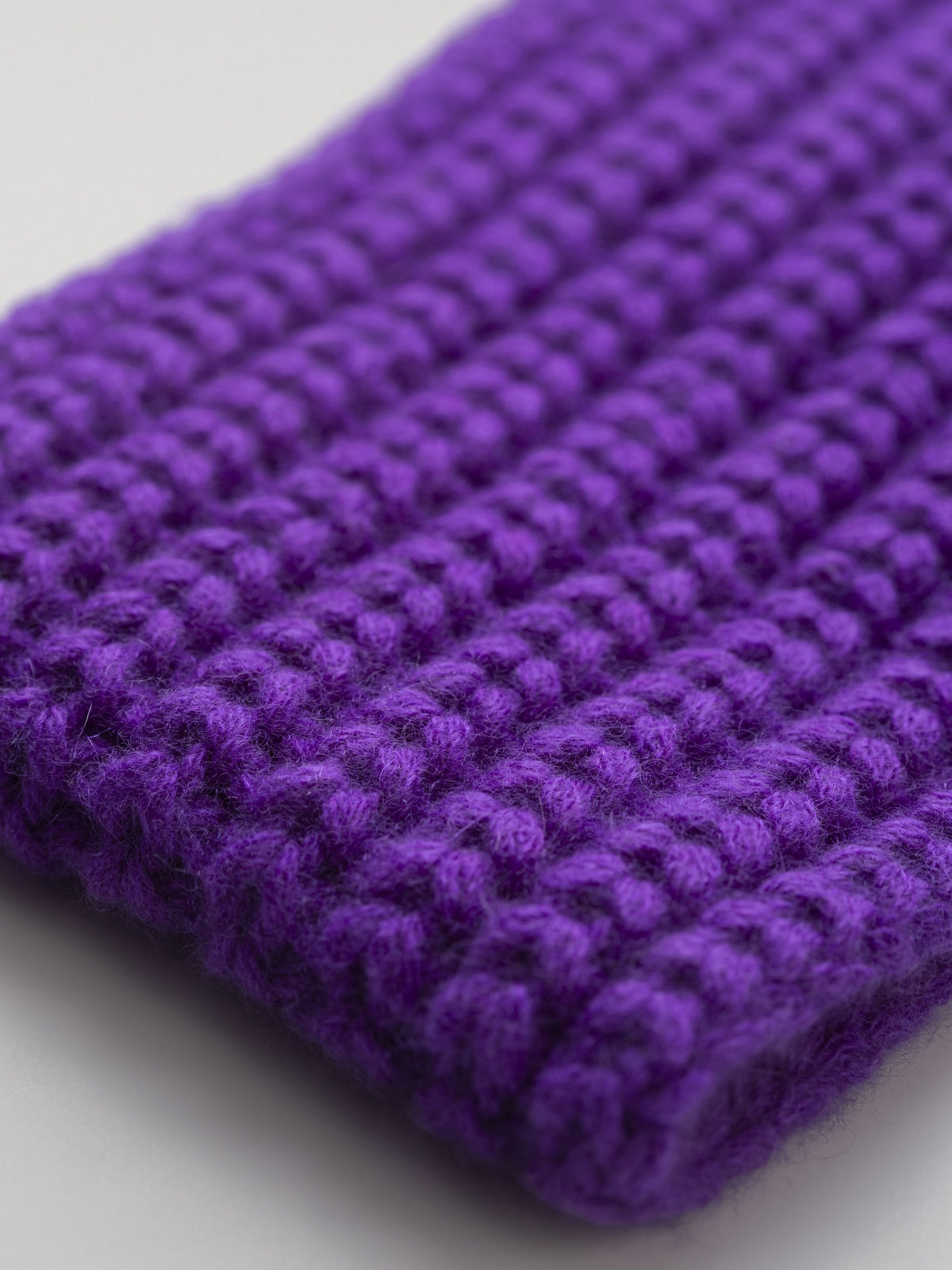 Close-up of the violet cashmere headband showing the ribbed stitch and soft yarn texture