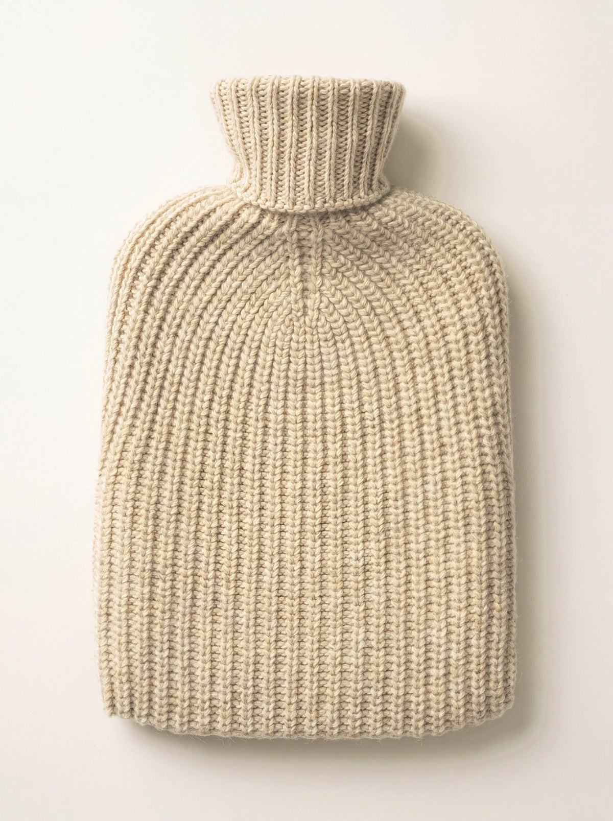 Oatmeal cashmere hot water bottle with a chunky ribbed knit cover and roll neck