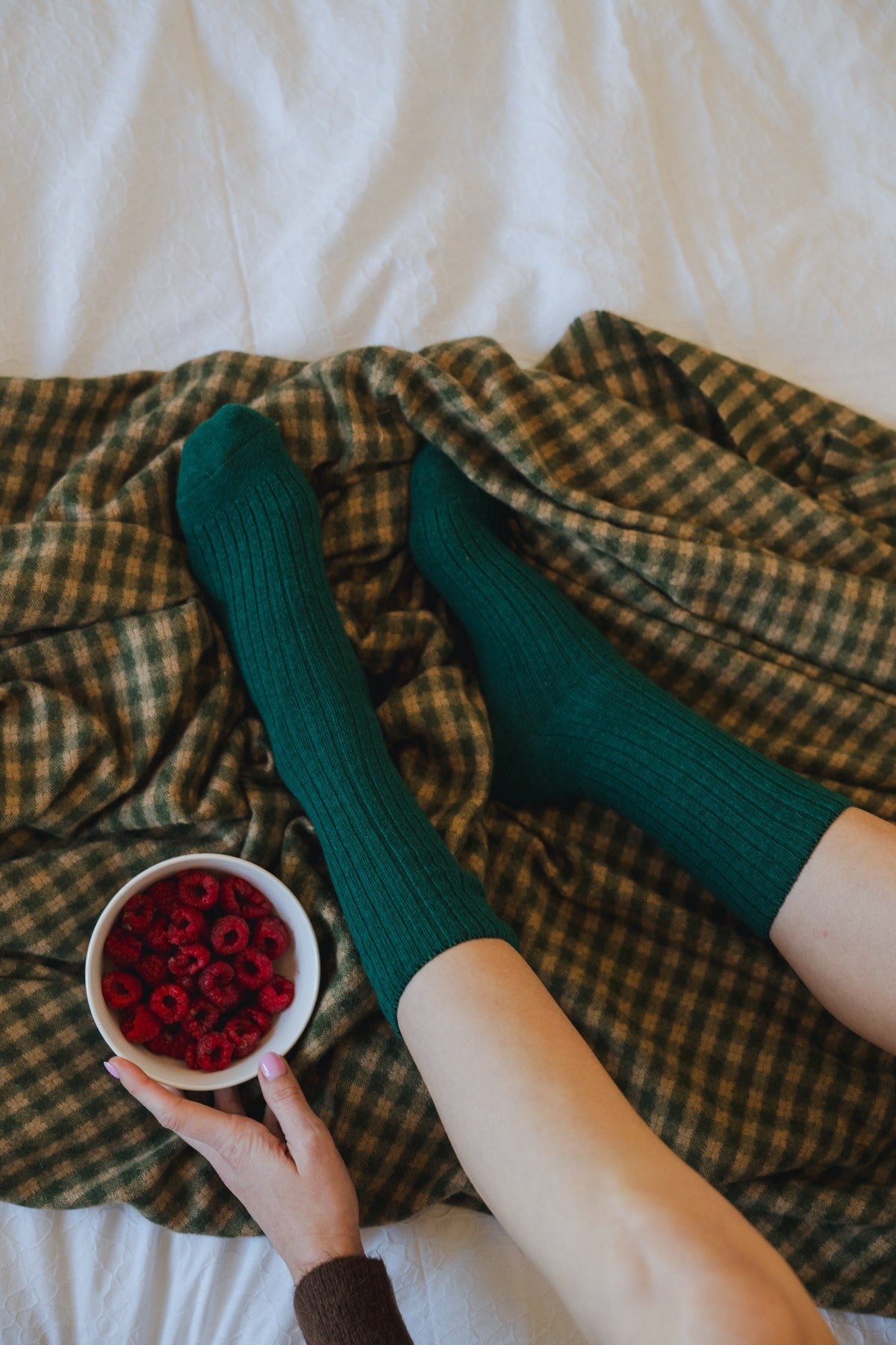 Top-down view of the ribbed green socks worn, showing the fine knit texture along the leg and foot