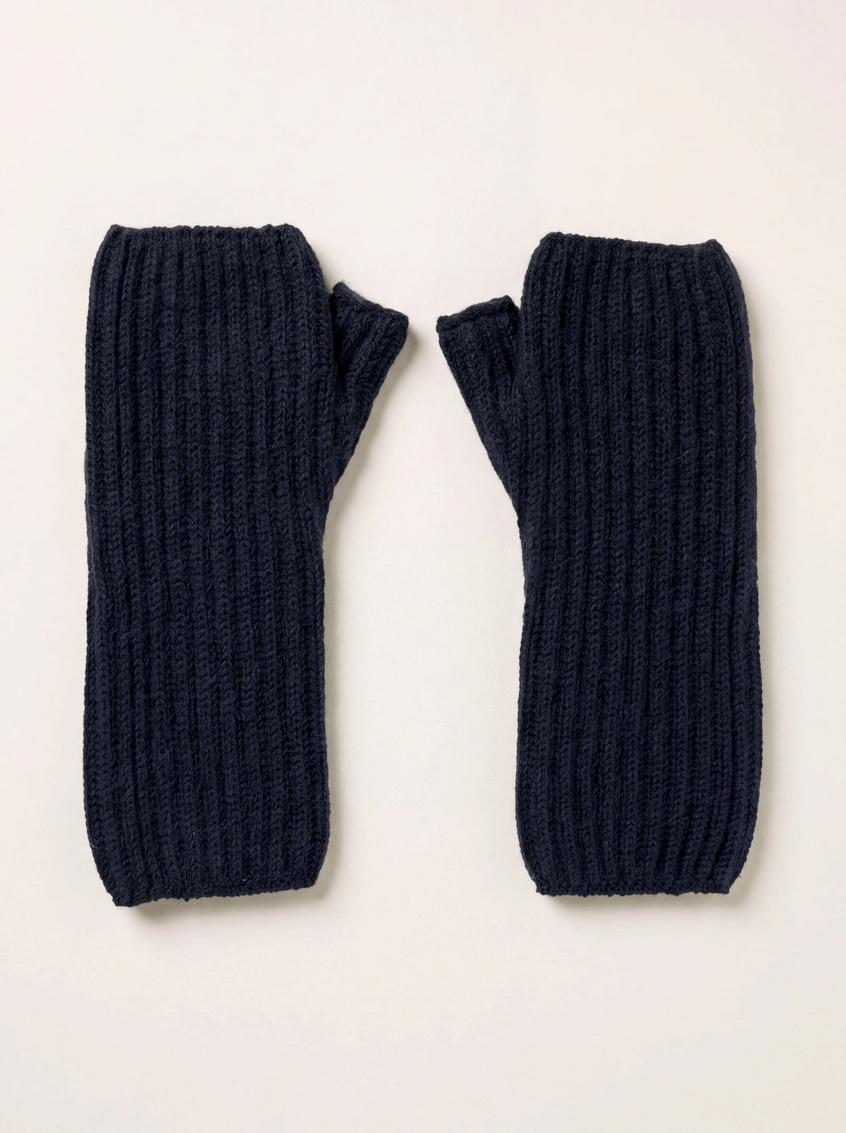 Dark navy ribbed cashmere wrist warmers with open thumb holes, laid flat as a pair