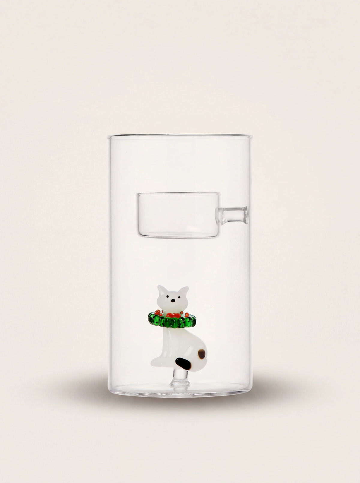 Clear glass tealight holder with an elevated cup above an internal cat figurine wearing a wreath