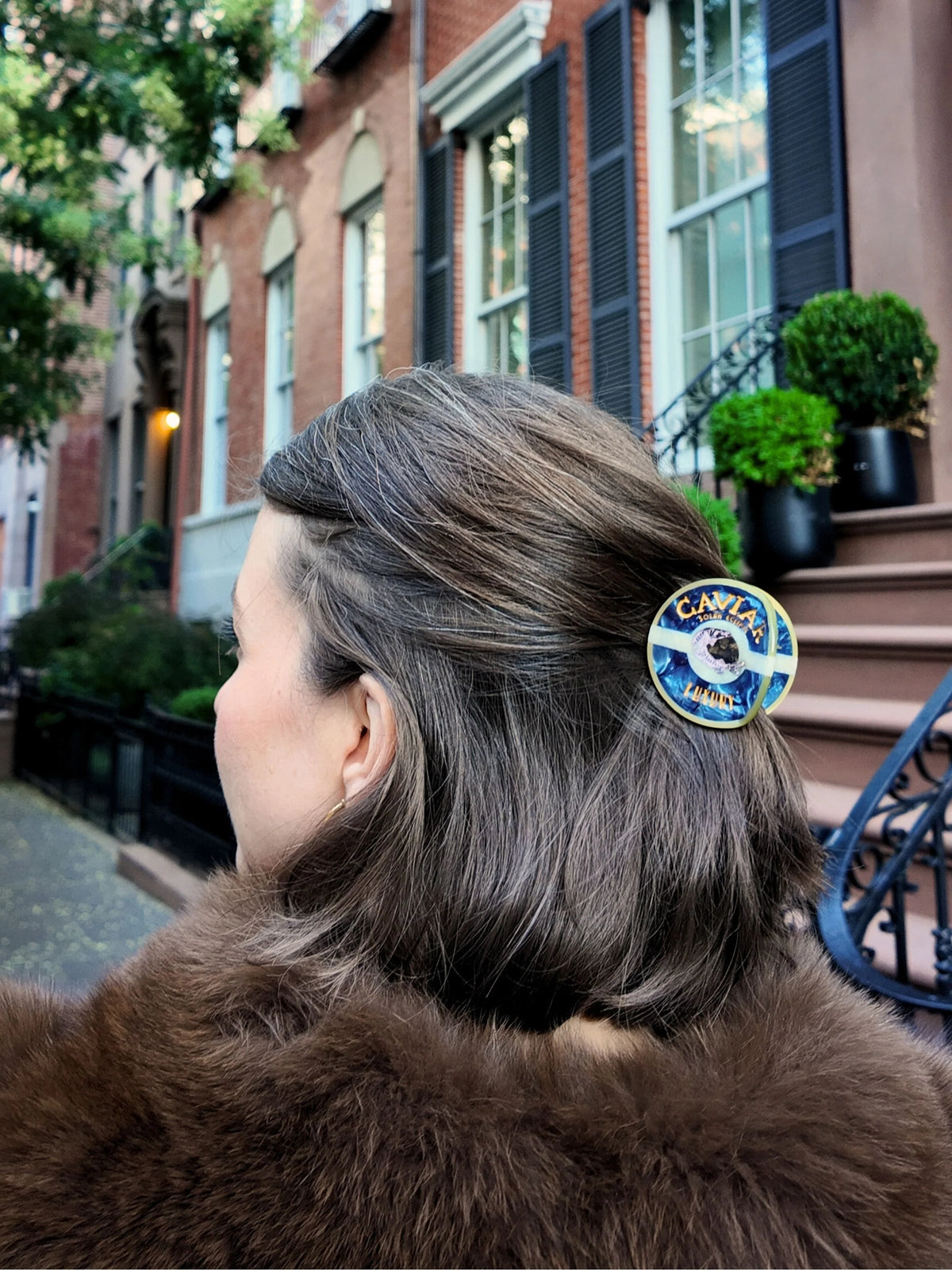 Caviar tin hair clip worn holding back brown hair in a half-up hairstyle