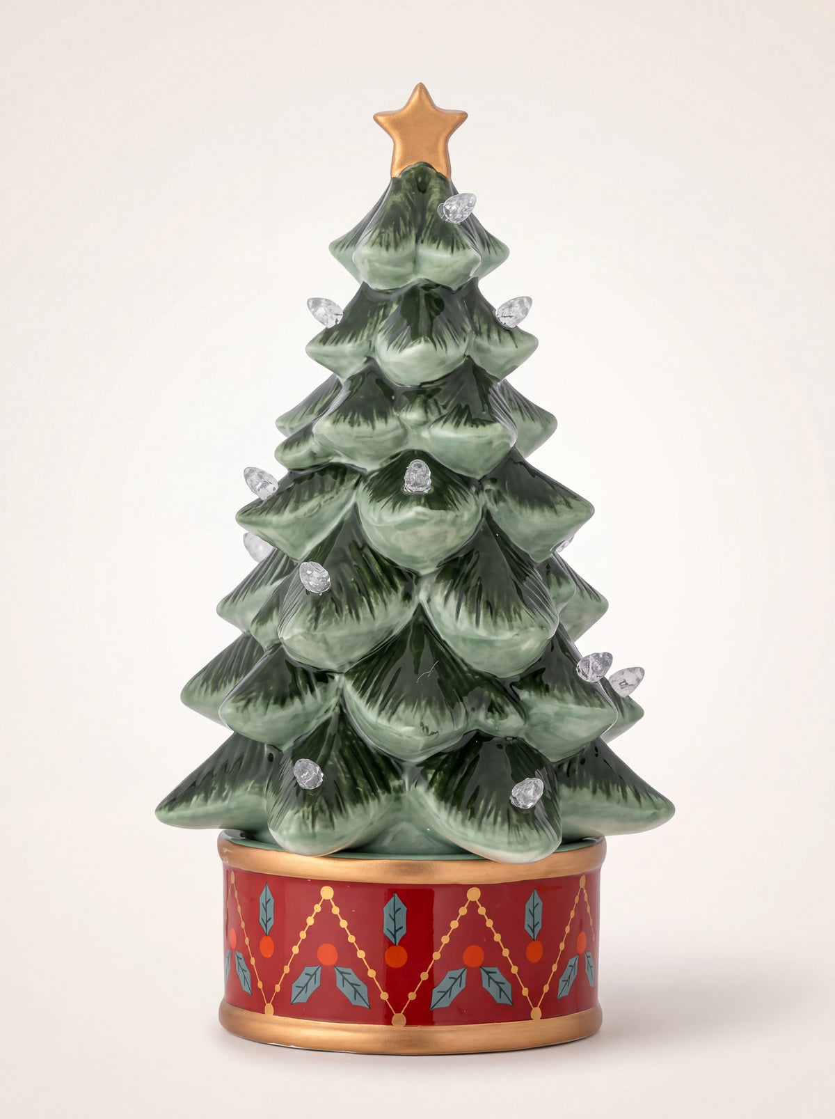 Glazed green ceramic Christmas tree with a gold star topper and red drum base