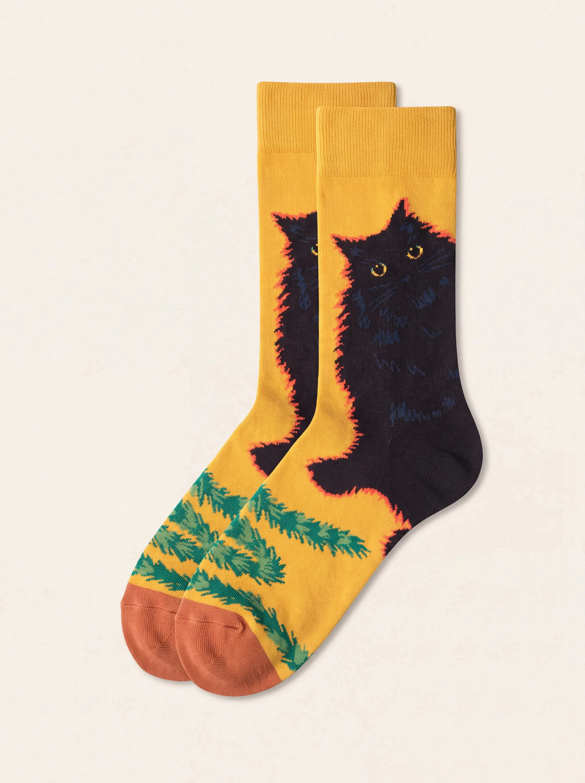 Yellow cotton socks with a black cat motif, green foliage along the foot and terracotta toes