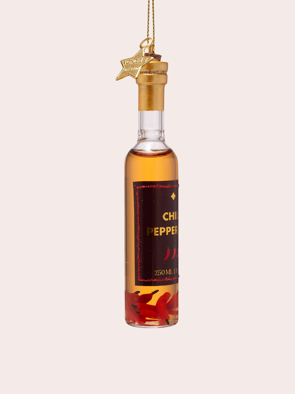 Three-quarter view of the bottle ornament showing the red glitter-trimmed label