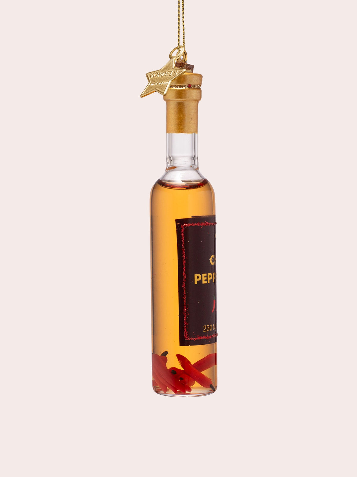 Side view of the glass ornament showing the red chillies resting at the base of the bottle