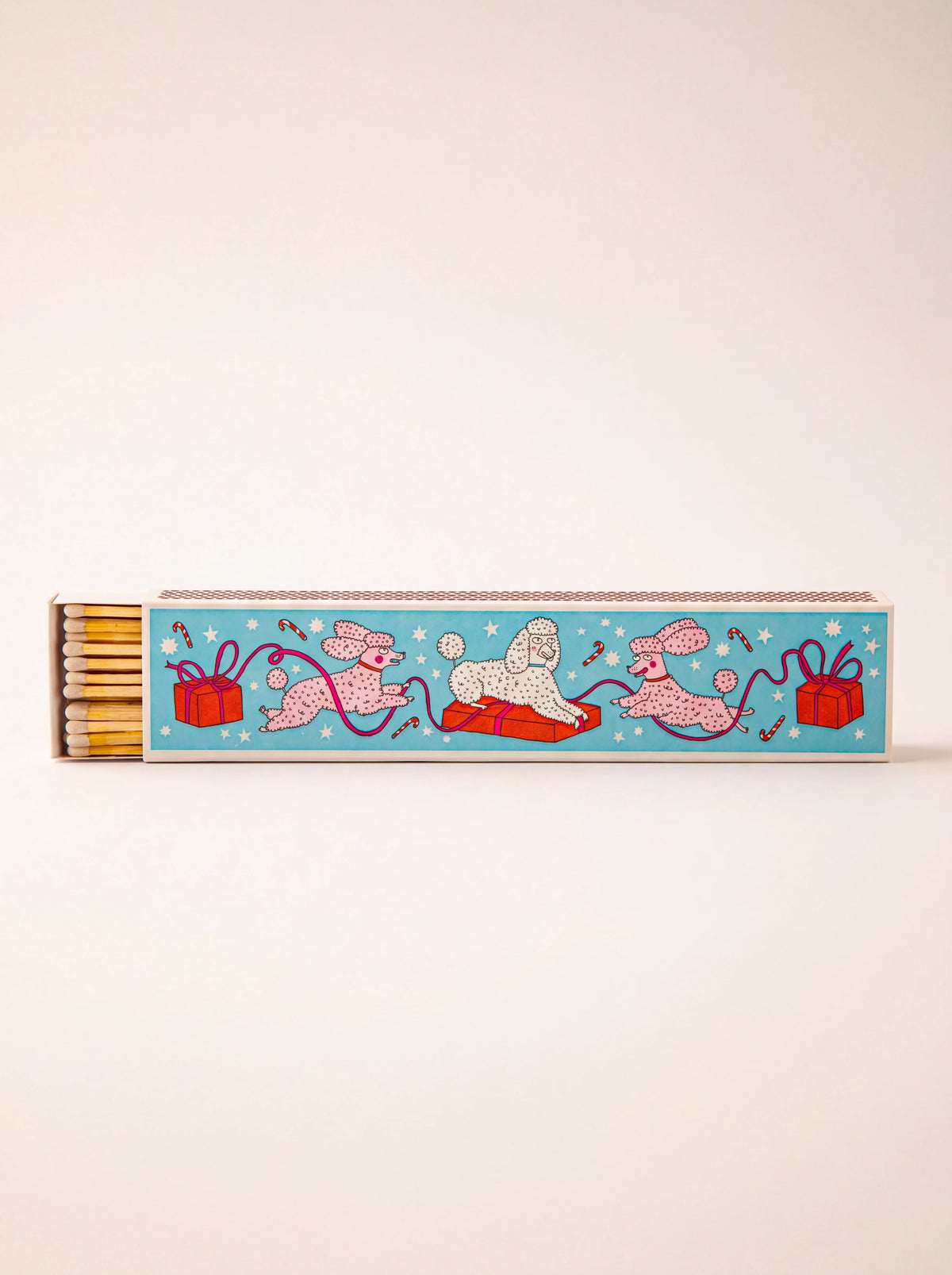 Long matchbox with festive poodle illustration on light blue, slid open to show yellow-tipped matches