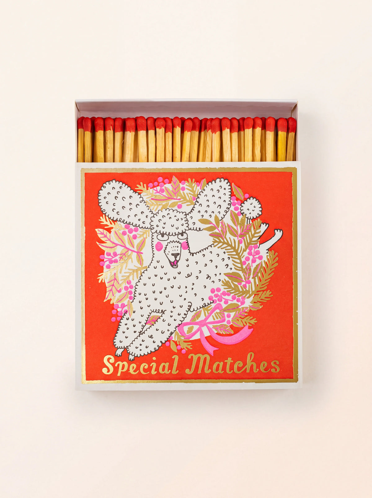 Square matchbox with an illustrated poodle and 'Special Matches' text, partially open to show red-tipped matches
