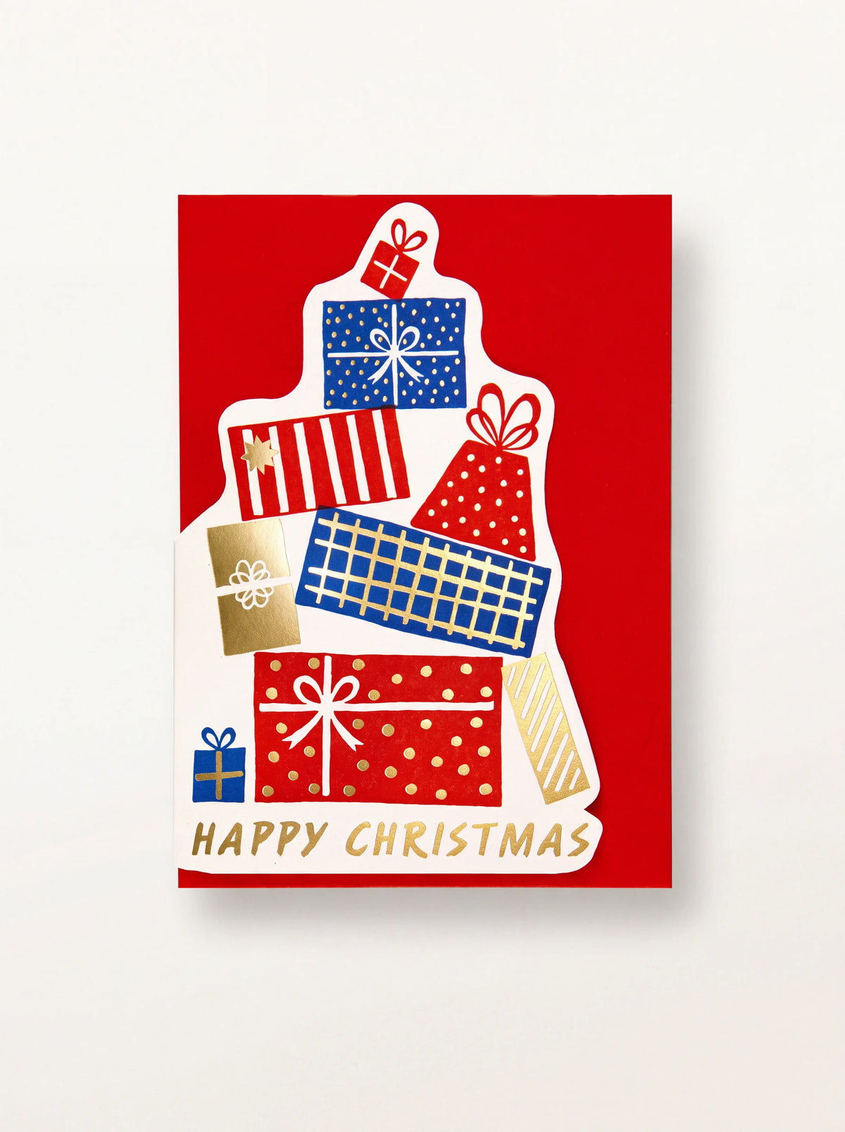 Red Christmas card with a cut-out stack of patterned presents and gold lettering reading HAPPY CHRISTMAS