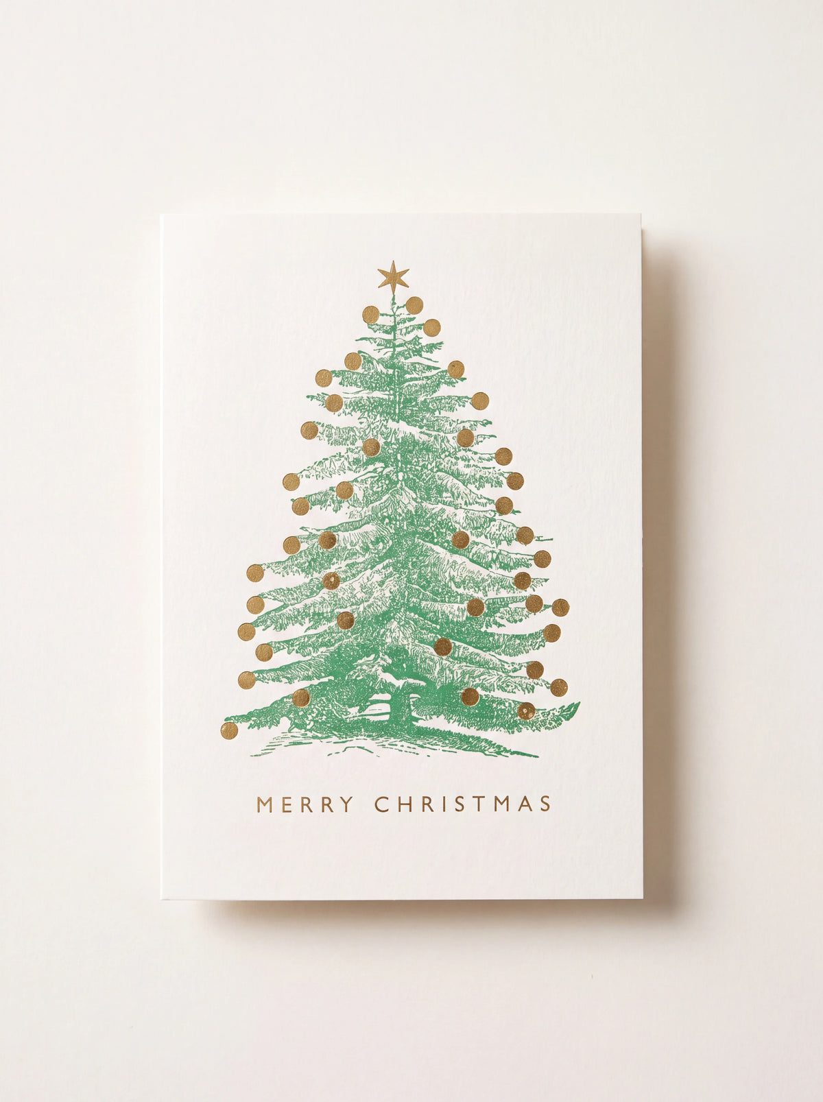 White paper Christmas card with a green illustrated tree, gold baubles, and text reading Merry Christmas