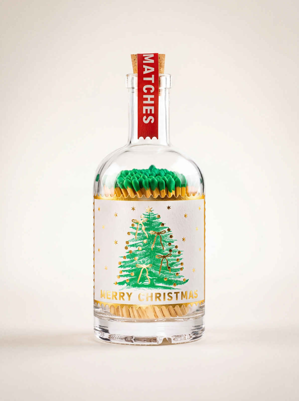 Clear glass match bottle with green-tipped matches, cork stopper and Merry Christmas tree label
