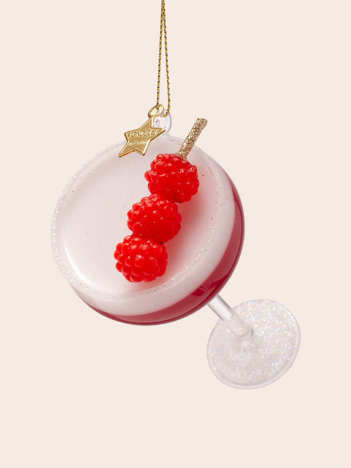 Top-down angle showing the white foam surface, fine glitter rim and three red raspberries on a pick