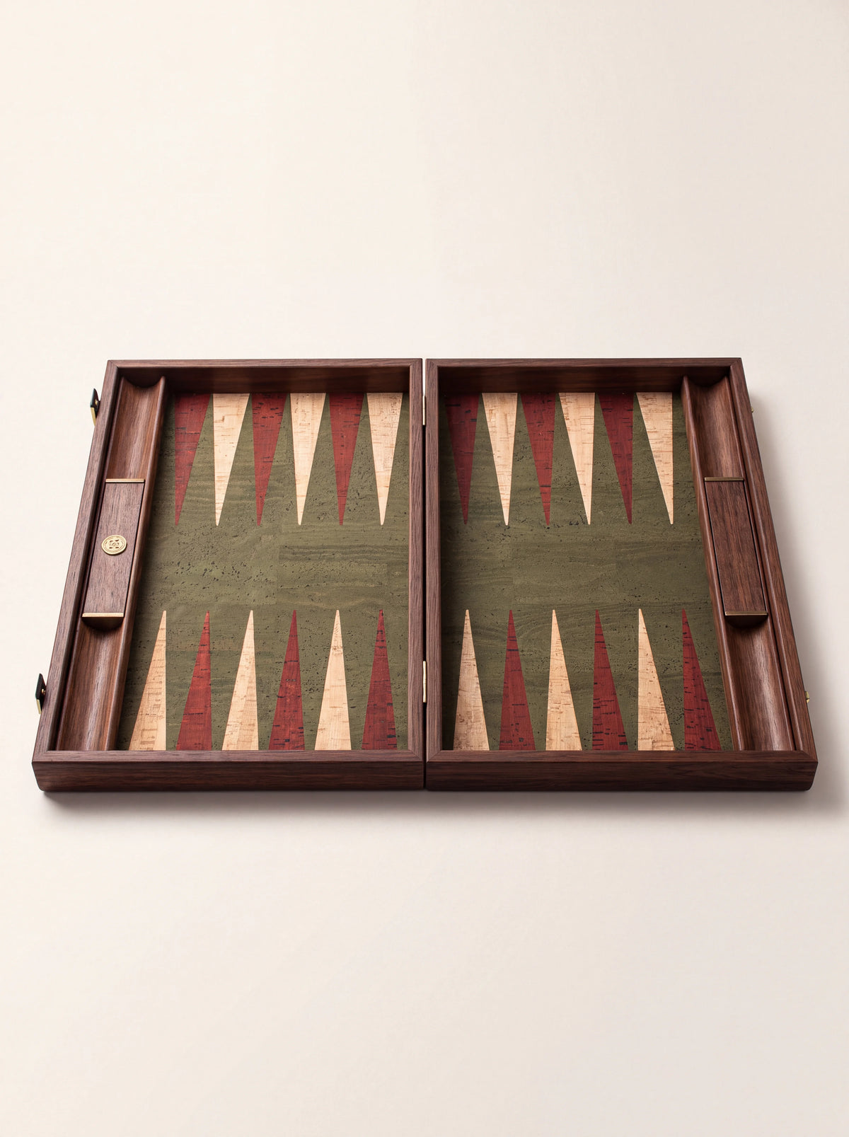 Open wooden backgammon board without pieces, showing the green cork field, inlaid points and side racks